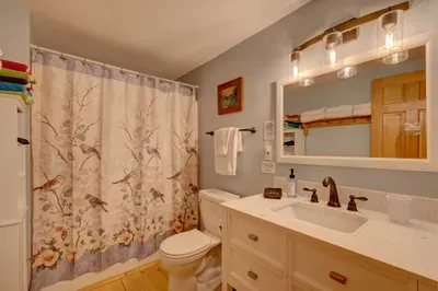 Updated bathroom with a spacious shower, fresh towels, and warm lighting for a relaxing reset.