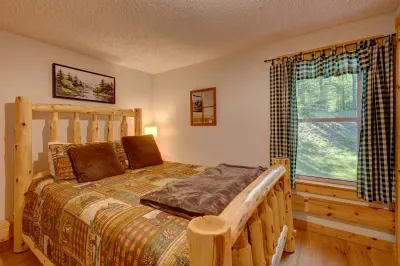 Primary bedroom with queen bed and blackout shades embodies simplicity and comfort.