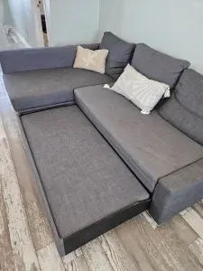 Tein day bed with spare sheets and pillows under the long side cushion.