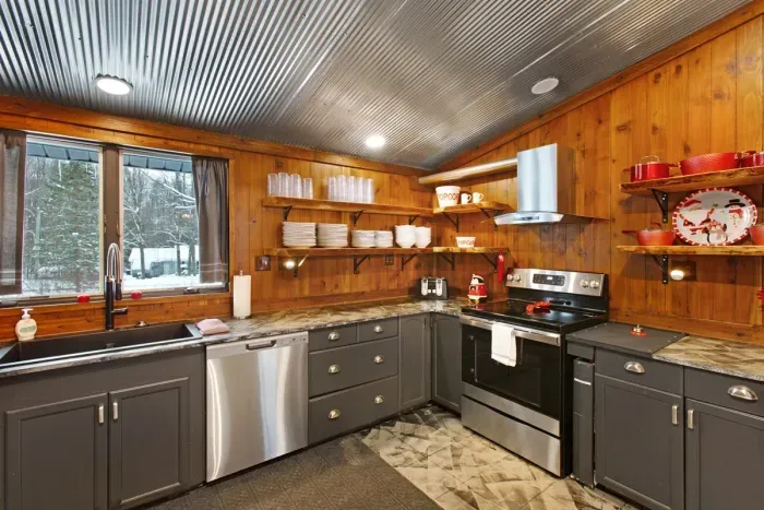 Fully equipped Kitchen with wooded front yard views and a view of whatever's on the big screen.