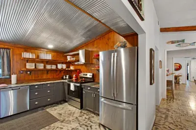 Fully equipped Kitchen with wooded front yard views and a view of whatever's on the big screen.