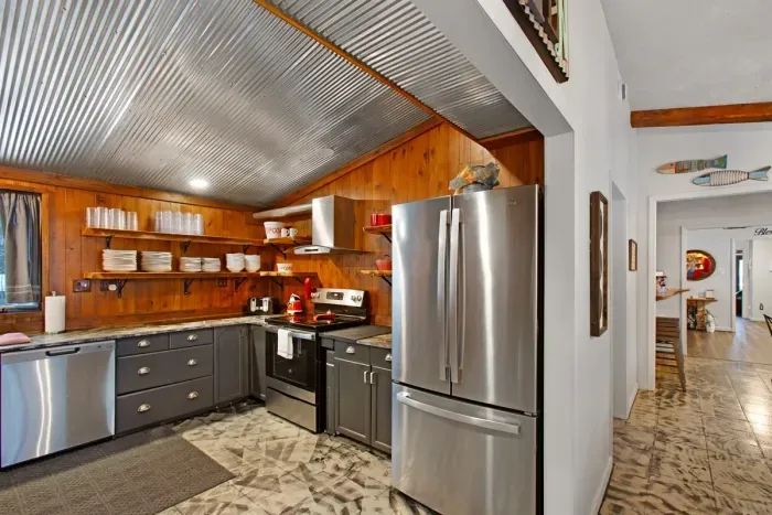 Fully equipped Kitchen with wooded front yard views and a view of whatever's on the big screen.