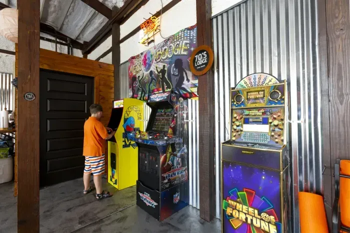 70's Lodge Pool House | Lounge Area | Changing Room | Work-out Equipment | Arcade Games | Indoor- Outdoor Smart TV's | Disco Lights | Radiant Heat | Dry Bar & Bar Stools | Refrigerator | Corn