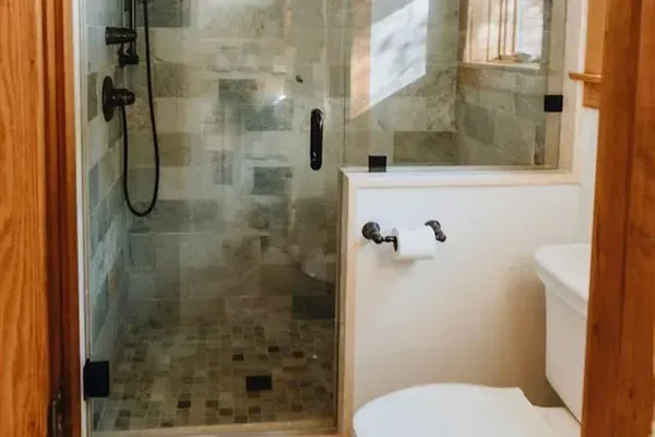 The shower and toilet are in a separate room within the larger bathroom for added privacy