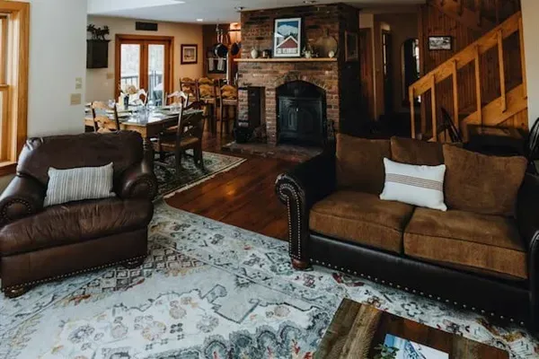 Living room looking towards the dining area and kitchen with the third floor loft above. Note that the wood stove is no longer available.