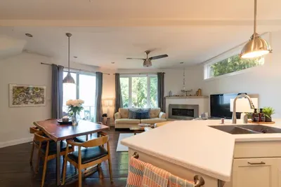 Up the stairs, the main level showcases a bright, open-concept living, dining, and kitchen area designed for comfort and functionality.