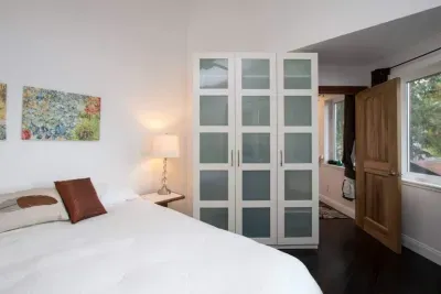 This bedroom features 4 opening windows, vaulted ceiling and a ceiling fan for a light airy feeling.