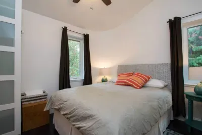 The second bedroom upstairs with comfortable queen size bed and two opening windows.