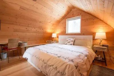The master bedroom with comfortable king size bed and whitewashed furniture.