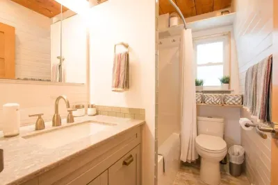 The newly renovated bathroom with sink, toilet and tub/shower, featuring either overhead or hand held shower.