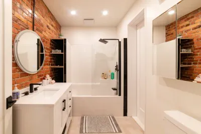 The bathroom with tub & rain shower, mirror lights up and clears steam as well.