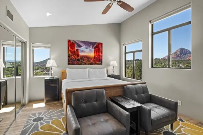 [Bedroom 1] The spacious primary suite features a plush king bed, leather armchairs, and gorgeous red rock views.
