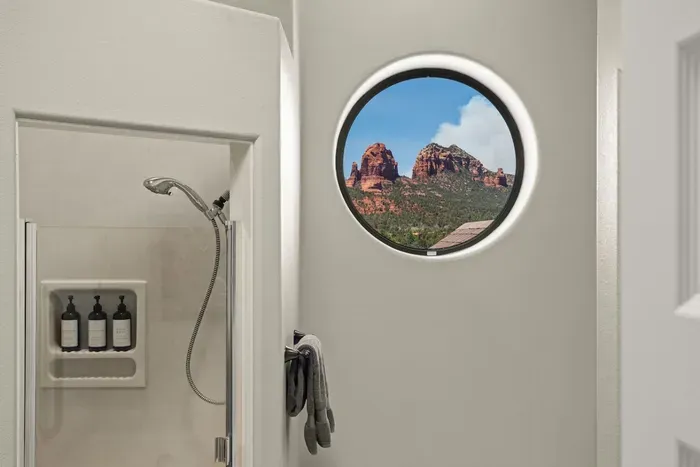 [Bathroom 2] Relax in the deep soaking tub while admiring red rock views through a charming porthole window.