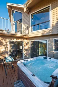 [Lower Level Deck] Slide open the glass doors for direct access to the private lower-level hot tub deck.