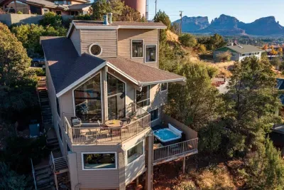 Here is an elevated perspective showcasing the home's multi-level decks, hot tub, and surrounding beauty.