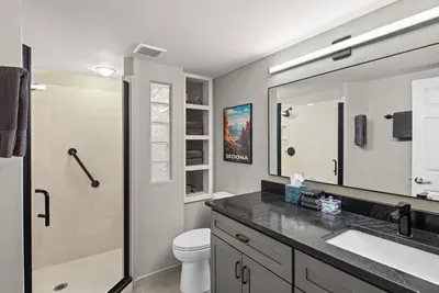 [Bathroom 2] The downstairs guest bathroom features a spacious walk-in shower and modern fixtures.