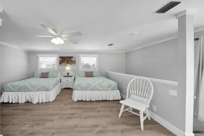 This "loft bedroom" is equipped with 2 queen beds, closet, and full-length mirror for guests preparing for a night out.