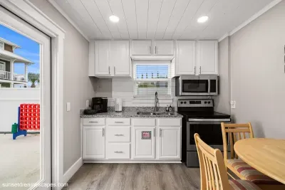 The secondary kitchen is the perfect place to entertain or store drinks and snacks for poolside enjoyment. The pool is located just through the French doors to the backyard.