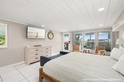 The downstairs beachside west bedroom is equipped with a king bed, seating area, and 55" Roku-enabled TV. Guests may relax after a sun-filled day in the private ensuite full bathroom.