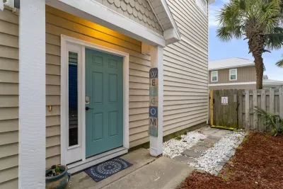 The entrance to the home is located just to the right side. In this photo, you can also see the gate that leads to the backyard and your own private pool! 