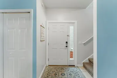 An interior view of the main front door, with laundry area located to the left and steps to the right.  The steps lead to the upper level, which is the main living area.