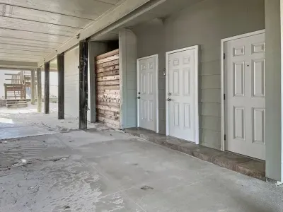 The access for the home is the door on the far right. The middle door is the elevator. Function of the elevator is not guaranteed, and at least one member of the party must be able to climb stairs in order to call the elevator from the main level.