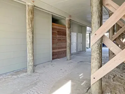 Parking located beneath the home. There is also a propane-fueled BBQ grill provided. Propane availability is not guaranteed and the tank may require refill at one of the local shops.