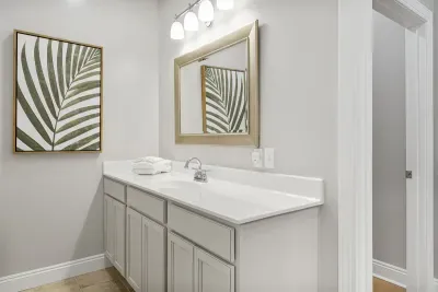 Primary suite en suite bathroom- the second of the two vanities- located in front of the potty room and linen closet.