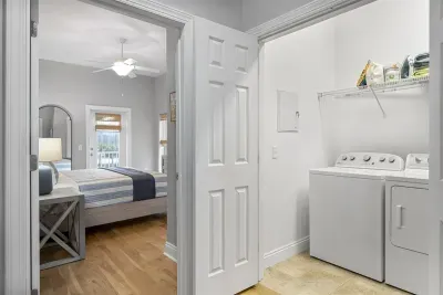 The laundry room is equipped with a washer, dryer, and extra drink fridge. The laundry room is located on the first level. You may also find items like step stools and dog bowls in this storage area.
