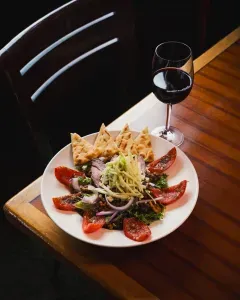 a picture of some gourmet food with a glass of red wine.