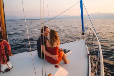 Two people sitting on the front of a sail boat in love