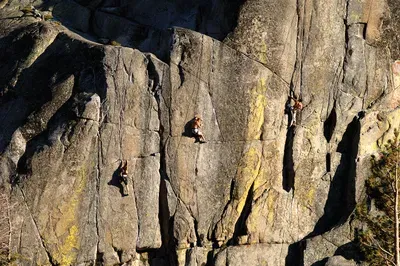 three climbers climbing three different routes at donner summit on a granite rock face