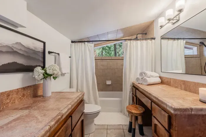 The ensuite bath with plenty of storage and full shower is located ensuite to our primary bedroom. 