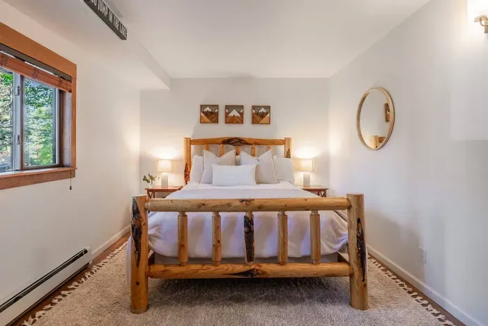 Our second bedroom features a queen timber framed bed, seating area and full sized closet. The large window faces the front yard and the hall bathroom is just steps away. 