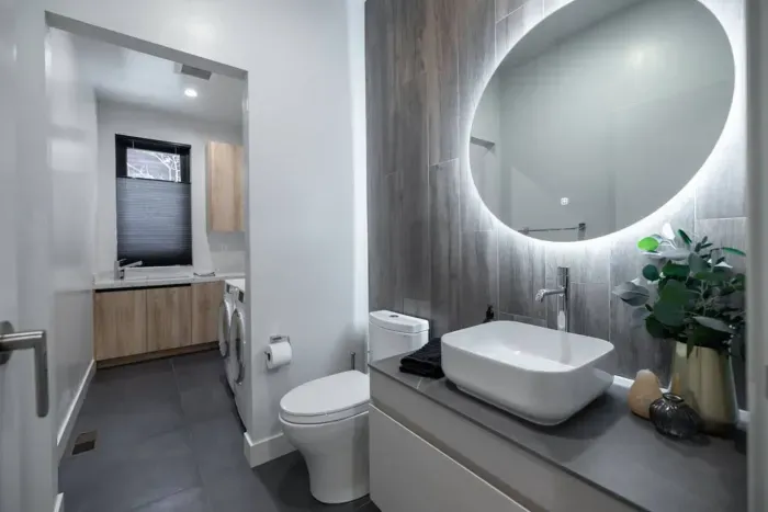 Here we have the half bathroom downstairs that is just off the kitchen and living room areas. It also doubles as the laundry room as you walk further in.