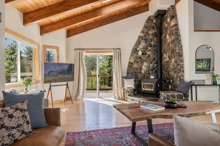 Comfortable leather couches, 55" TV, wood burning fireplace and easy access to the large upper level decks make the upstairs living room a favorite! The kitchen and dining room are located just to the right.