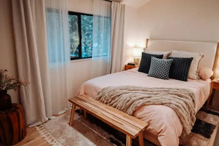 The back bedroom is quiet and cozy with lofted ceilings, high quality linens, and a queen sized bed