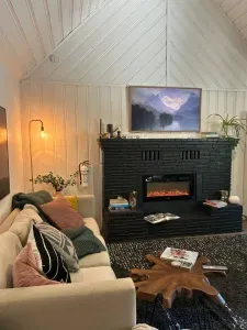 The living room has an electric fireplace and a 55" television (set to art mode here) and a cozy, extra large sofa.