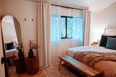 The back bedroom has a queen sized bed, lofted ceiling, full length mirror and a bench seating area.