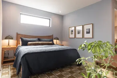 Welcome to the primary bedroom at the Lake Trail Lodge! Located on the ground floor, this room features a king sized bed, comfortable cotton and linen bedding, a walk-in closet, and its own ensuite bath with soaking tub and shower.