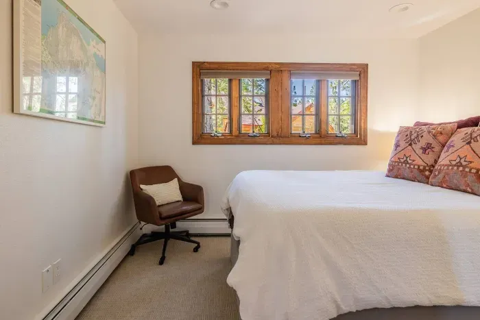 This is bedroom #4, which features a queen-sized bed and is located at the turn in the  L-shaped hallway.