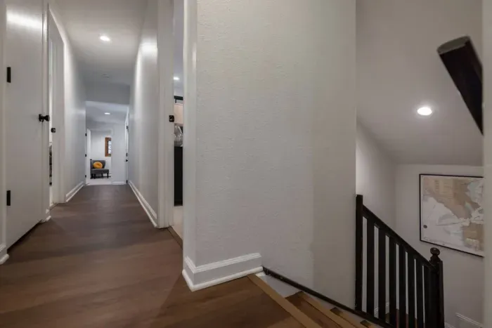 The view at the top of the stairs looking down the L-shaped hallway. Most of the bedrooms in the home are located on this level, as well as 2.5 bathrooms and the laundry room. 