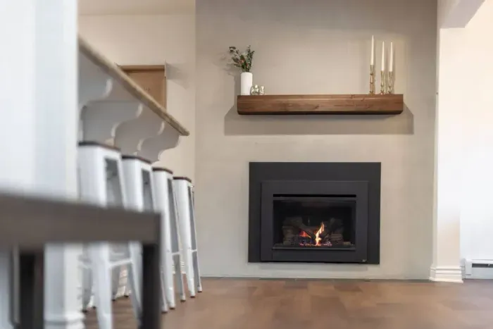 An updated gas fireplace just off of the kitchen's breakfast bar. One of four fireplaces in the home!