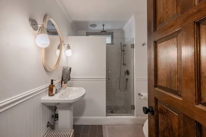 The downstairs full bathroom is centrally located near the kitchen and billiards room. It features a walk-in shower complete with soap, shampoo, and conditioner.