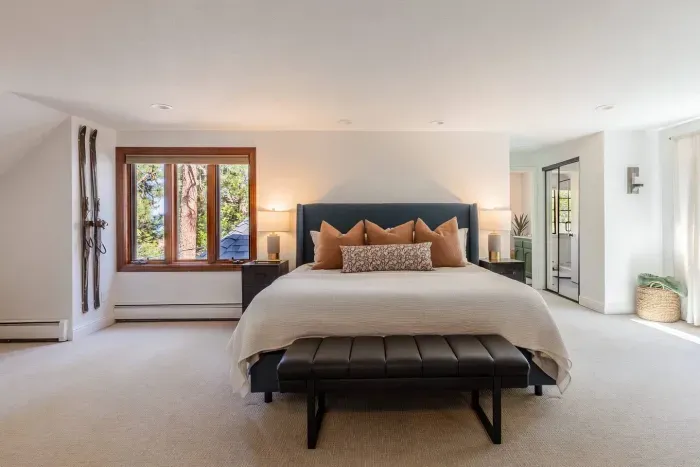 The primary suite is super spacious, It features a king-size bed, desk, fireplace, small sectional sofa and lots of natural light.