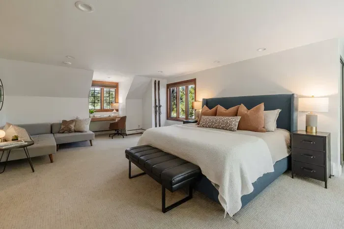 More angles on the primary bedroom upstairs, which features a sitting area, work-from-home desk, ensuite bathroom, and a gas fireplace.