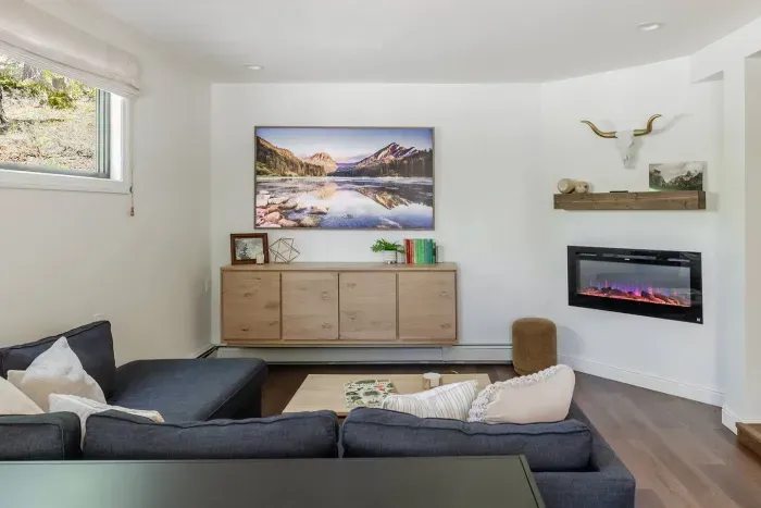 This secondary living room features a 75" Samsung Frame TV and an on-demand electric fireplace.
