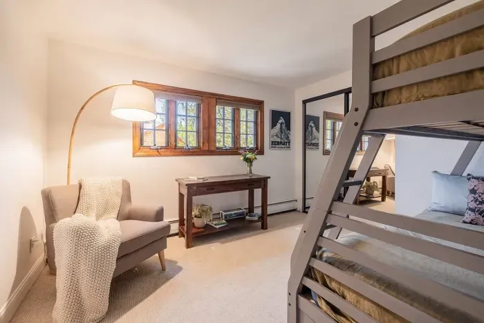 Here is bedroom #5, which features a twin-over-full bunk bed, seating area, and books and games.