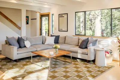 75" flat screen CanvasTV, extra large comfortable sectional, and stunning views from every window. You can see the stairwell to the upstairs just behind the sofa.

photography by @pamcakes