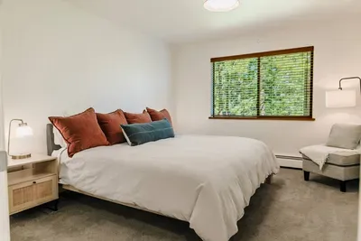 Our downstairs bedroom which features a king size bed, larger closet with dresser, seating area and a view of the forest. The downstairs bathroom is just steps away. 

photography by @dirtandglass